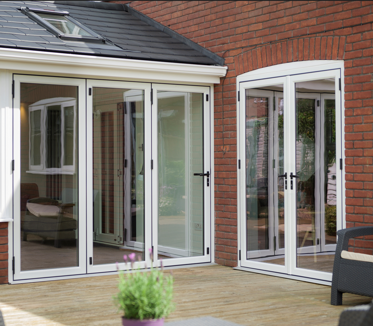 Large bifold door system opening onto garden, offering seamless indoor-outdoor living.